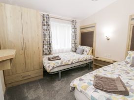 A bedroom with two beds and a wardrobe at Beechwood Lodge 