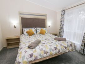 A bedroom with a bed and decorative pillows at Beechwood Lodge