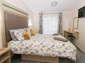 A bedroom with a bed and mirror at Beechwood Lodge