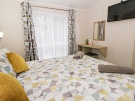 A bedroom with a bed and desk at Beechwood Lodge 