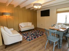 A living room with a sofa, dining table, and flat-screen TV at Shearers in Llandysul