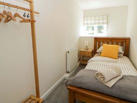 A bedroom with a single bed and a clothing rack at Shearers in Llandysul