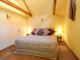 A bedroom with a bed and bedside tables at The Old Cow Shed