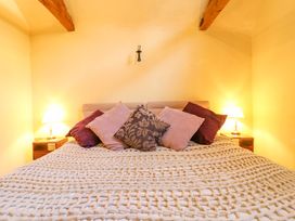 A bedroom with a bed and pillows at The Old Cow Shed in 