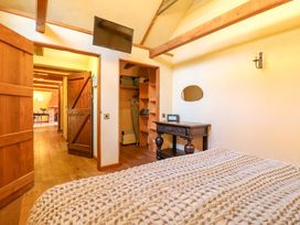 A bedroom with a bed and a television at The Old Cow Shed in 