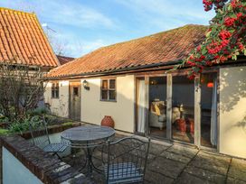 An outdoor area with a table and chairs at The Old Cow Shed in 