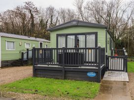 A caravan with a deck at Borewicks Lakes