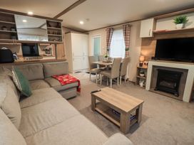 A living room with a sofa coffee table and television at Caravan