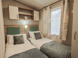A bedroom with two beds and a shelf at Caravan