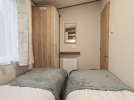 A bedroom with two beds and a mirror at Caravan