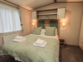 A bedroom with a bed and shelves at Caravan