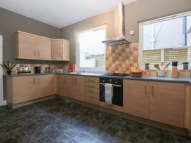 A kitchen with cabinets and appliances at Canning Lodge in Colwyn Bay