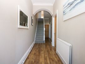 A hallway with stairs and a mirror at Canning Lodge in Colwyn Bay
