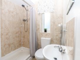 A bathroom featuring a shower, toilet, and sink at Canning Lodge in Colwyn Bay