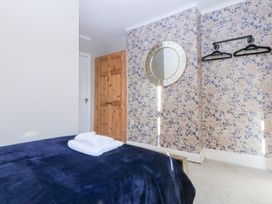 A bedroom with a bed and mirror at Canning Lodge in Colwyn Bay