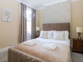 A bedroom with a bed and bedside tables at Canning Lodge in Colwyn Bay