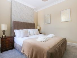 A bedroom with a bed and side tables at Canning Lodge in Colwyn Bay