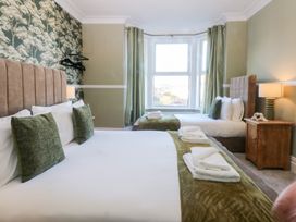 A bedroom with two beds and a window at Canning Lodge in Colwyn Bay
