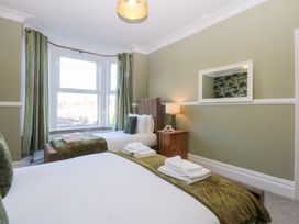 A bedroom with two beds and a window at Canning Lodge in Colwyn Bay