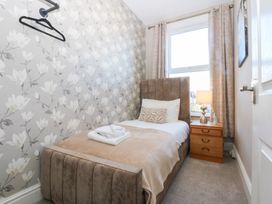 A bedroom with a single bed and a side table at Canning Lodge in Colwyn Bay