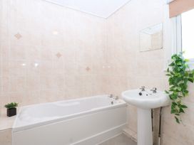 A bathroom with a bathtub and a sink at Canning Lodge in Colwyn Bay