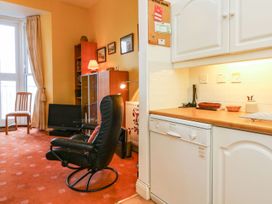A living room with a chair and television at Val's Seaview in Ilfracombe