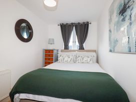 A bedroom with a bed and wooden cabinet at 18 Pagoda Drive St. Austell