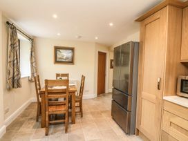 A kitchen with a dining table and refrigerator at The Coach House in Carnforth
