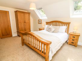 A bedroom with a bed and wardrobe at The Coach House in Carnforth