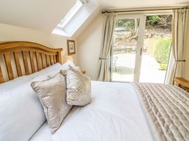 A bedroom with a bed and door leading to outdoor area at The Coach House in Carnforth