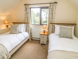 A bedroom with two beds and a window at The Coach House in Carnforth