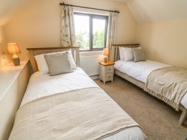 A bedroom with two single beds and a window at The Coach House in Carnforth