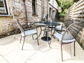 A table with chairs and a bottle on a patio at The Coach House Carnforth