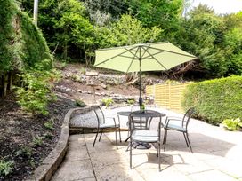 A garden with a table and chairs under an umbrella at The Coach House in Carnforth