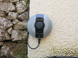 An electric vehicle charging point mounted on a wall at The Coach House in Carnforth