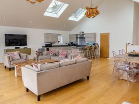 A living room with a kitchen area and a television at 2 Remera St. Ives