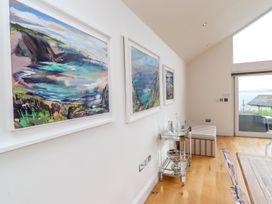 A living room with paintings and a glass table at 2 Remera in St. Ives