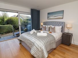 A bedroom with a bed and sliding door to a balcony at 2 Remera St. Ives