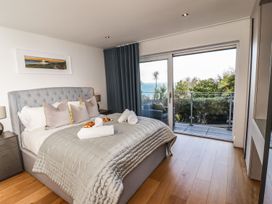 A bedroom with a bed and sliding door at 2 Remera in St. Ives
