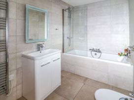 A bathroom with a bath, sink, toilet and mirror at 2 Remera in St. Ives