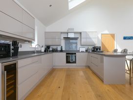 A kitchen with modern appliances and wooden flooring at 2 Remera St Ives