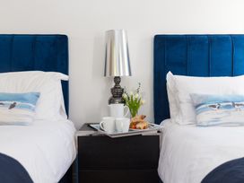 A bedroom with two beds and a tray of food at 2 Remera in St Ives