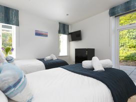A bedroom with two beds and a television at 2 Remera in St Ives