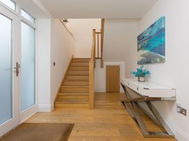 A hallway with a staircase and console table at 2 Remera St Ives