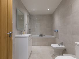 A bathroom with a bathtub, toilet, sink, and mirror at 2 Remera in St Ives