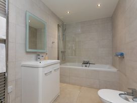 A bathroom with a bathtub, shower, sink, and toilet at 2 Remera in St Ives