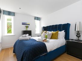 A bedroom with a bed and side table at 2 Remera in St Ives