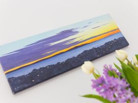 A painting of a sunset and a flower arrangement at 2 Remera St Ives