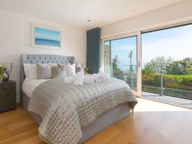 A bedroom with a bed and balcony at 2 Remera St Ives