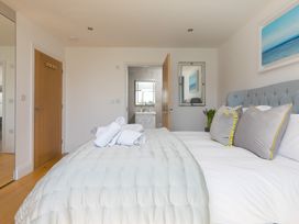 A bedroom with a bed and towels at 2 Remera in St Ives